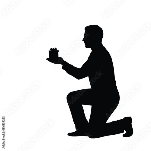 Man kneeling in silhouette offering a small object silhouette