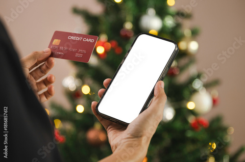 woman using Mobile holiday shopping payment person holding smartphone and credit card to complete secure online transactions during festive Christmas season