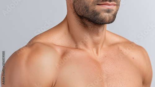 Close up of male shoulder and upper arm with mild rough skin texture, healthy complexion, stubble beard, and neutral expression, studio lighting, adult, wellness concept