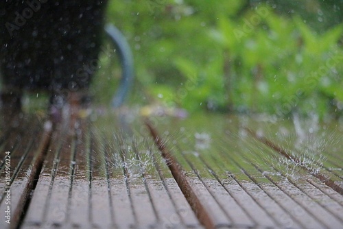 heavy rain falls on wooden Panels and splashes in the puddles
