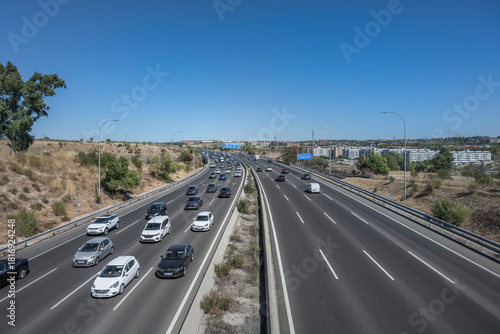 Commercial avenue with heavy traffic and public transport mingling with private vehicles on a weekday