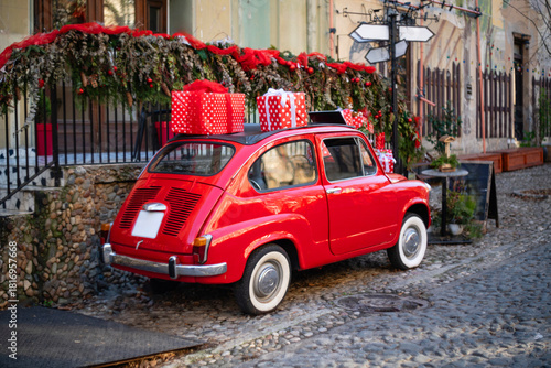 Old retro red car as a christmas decoration on a city street