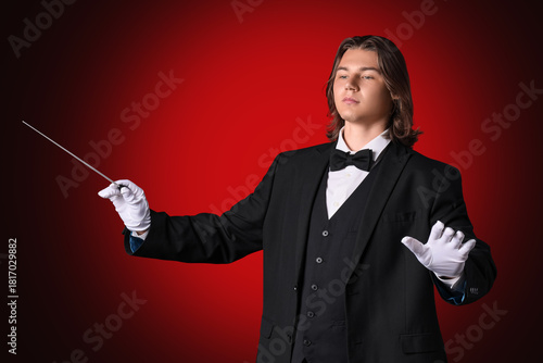 Male conductor on dark red ...