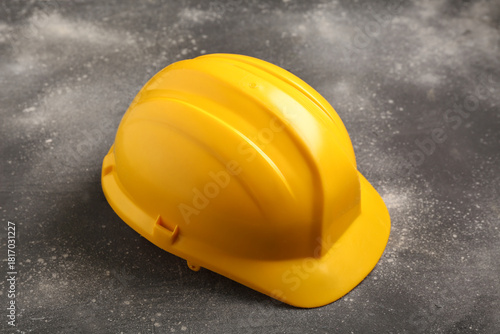Yellow hardhat on grey grun...