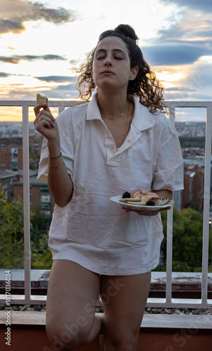 Принти на полотні Caucasian woman enjoying dessert outdoors during sunset