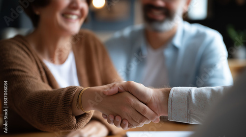 Couple meeting financial advisor at residence faceless clients and consultant defocused home background handshake agreement moment finance insurance advice property investment