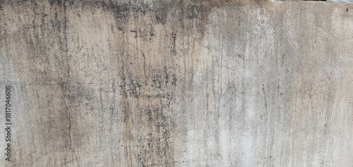 The view of an old weathered concrete wall featuring cracks and natural aging patterns. Ideal for use as a textured background in design, architecture references, or artistic visual projects.