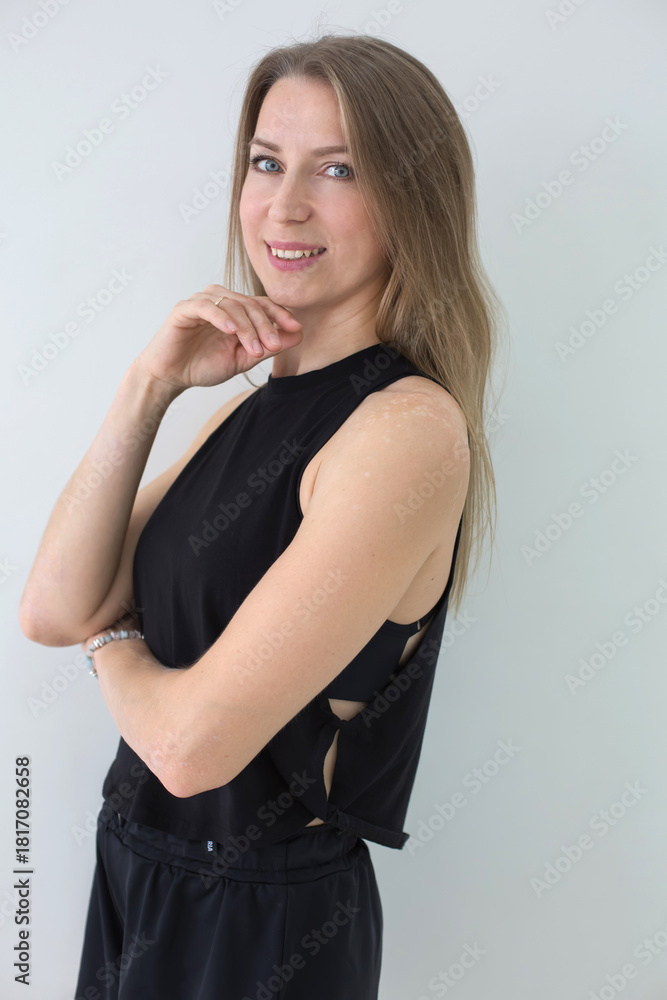 Fototapeta premium Smiling Woman in Black Athletic Wear Posing Against White Background
