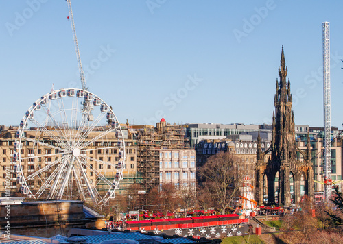 The Scottish city of Edinburgh showing the old church and the Ferris wheel of the Christmas market behind it.