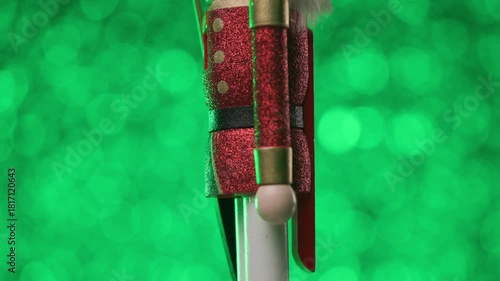 The Nutcracker is spinning to face the camera on a vibrant green background