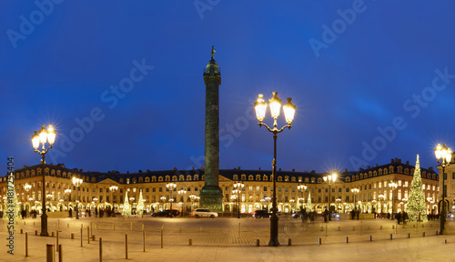 Fototapeta Naklejka Na Ścianę i Meble -  Vendome column with statue of Napoleon Bonaparte, on the Place Vendome decorated for Christmas at night , Paris, France. Vendome column has 425 spiraling bas-relief bronze plates were made out of