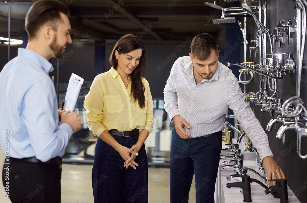 Obraz premium Salesman aids family couple in plumbing shop, selecting shower or tap for home renovation purchase, providing water fixture guidance in retail space dedicated to bathroom improvement and buying.