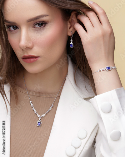 Elegant woman wearing luxury silver jewelry set with blue sapphire stones and diamonds