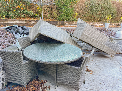Rattan garden furniture piled up after the impact of very strong winds from a storm. No people.