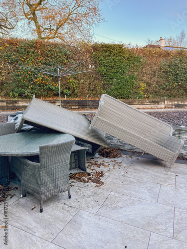 Rattan garden furniture piled up after the impact of very strong winds from a storm. No people.