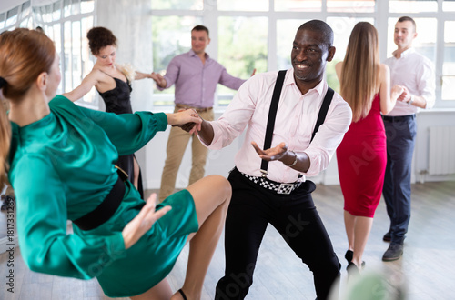 Tableau sur toile Pair of woman and African American man enjoying of contemporary boogie woogie dance in choreo class