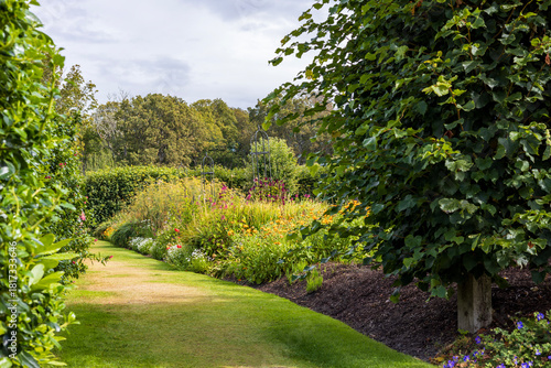 Fotografie Sunlit green pathway in the formal gardens of Dunrobin Castle, northern Scotland
