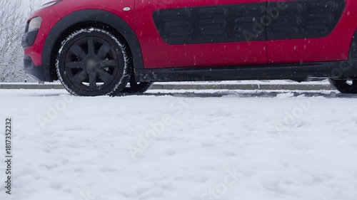 Car brakes engage on icy slope with wheels slipping during winter drive