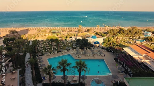 Beautiful timelapse view from hotel balcony of Aegean Sea with large pool and busy beach on background. Rhodes. Greece. 