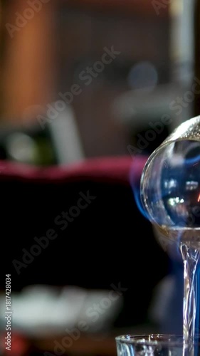 The bartender sets fire to the sambuca in a beautiful wine glass and pours it into another. preparing cocktails at the bar. High quality 4k footage