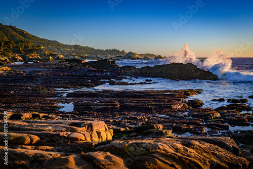 Point Lobos Weston Beach low tide with crashing surf. Late autumn golden hour sunset casting warm tones.