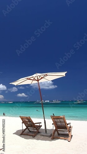 Sun umbrella and beach chairs on tropical beach. Summer vacation. Boracay. Vertical footage