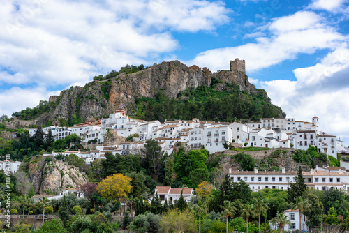 Zahara de la Sierra village built on a hillside with a historic castle above in Pueblos Blancos of Andalusia, in Spain