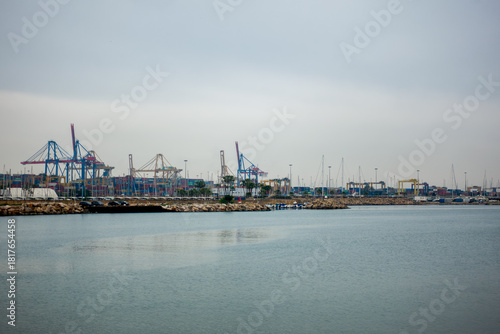 Port of Valencia Spain with cargo cranes and moored boats under