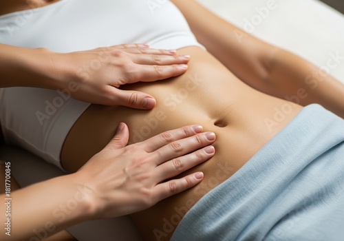 Gentle hands performing abdominal massage on a woman toned midsection