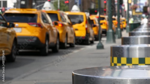 Manhattan Midtown street New York City, United States. Defocused row of yellow taxi cars. Many taxi cabs in line on 8th avenue near Penn Station. Taxi queue, urban road traffic, passenger transport.