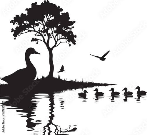 Black silhouette of a goose and ducklings on a lake with birds flying