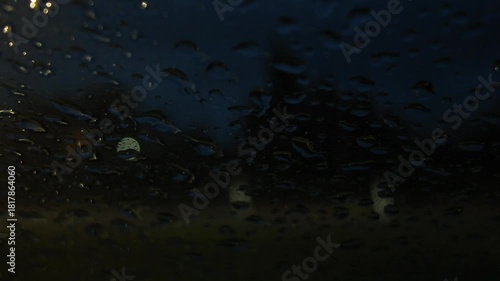 A captivating view of blurred red and yellow car lights seen through a rain-drenched window, evoking a moody and dreamlike atmosphere at night.