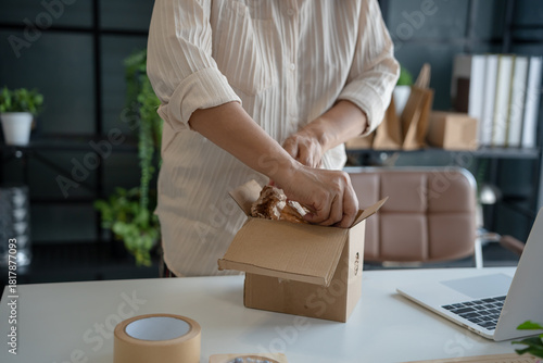 Mature asian woman business E-commerce entrepreneurship owner preparing Packing packages In Cardboard Box to ship to customers.