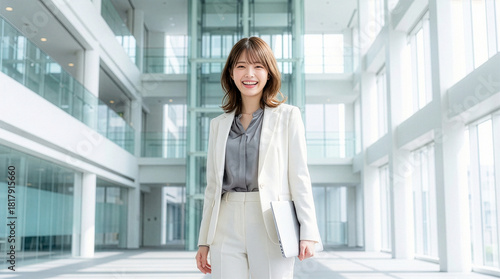 ノートパソコンを持つカジュアルスーツを着た笑顔の女性