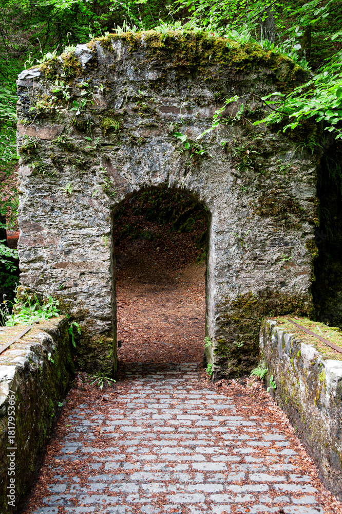 Obraz premium Old stone arch on walkway over river