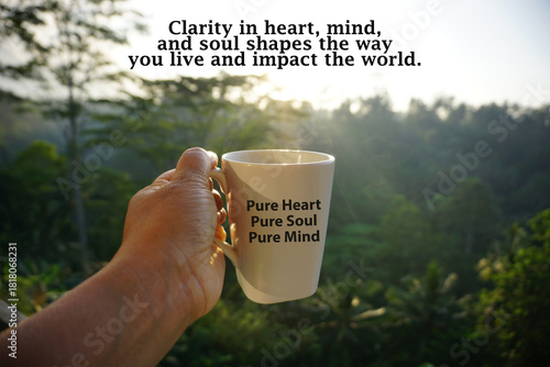 Inspirational quote - Clarity in heart, mind, and soul shapes the way you live and impact the world. With person holding cup of coffee or tea in hand with text pure heart, soul and mind against forest