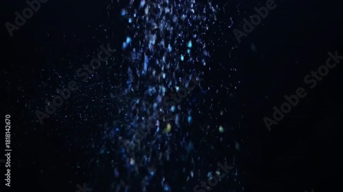 A magic blue water splash with ice snowflakes and winter stars creates a glowing galaxy texture against a cold black night sky