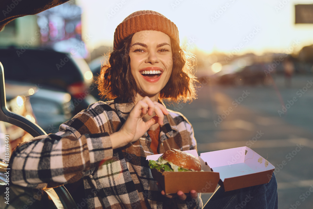 Φωτογραφία Woman with wide smile holding a takeout burger outdoors at golden hour, candid authenticity and joyful expression conveying mindful living and emotional storytelling in urban lifestyle