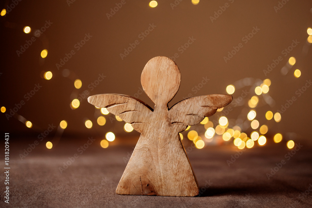 Obraz premium Rustic wooden angel figurine on holiday lights