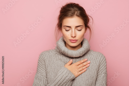 Serene beauty embraces tranquility, hand over heart, in a cozy moment of self-care and mindful peace against a soft pink backdrop for wellness campaigns