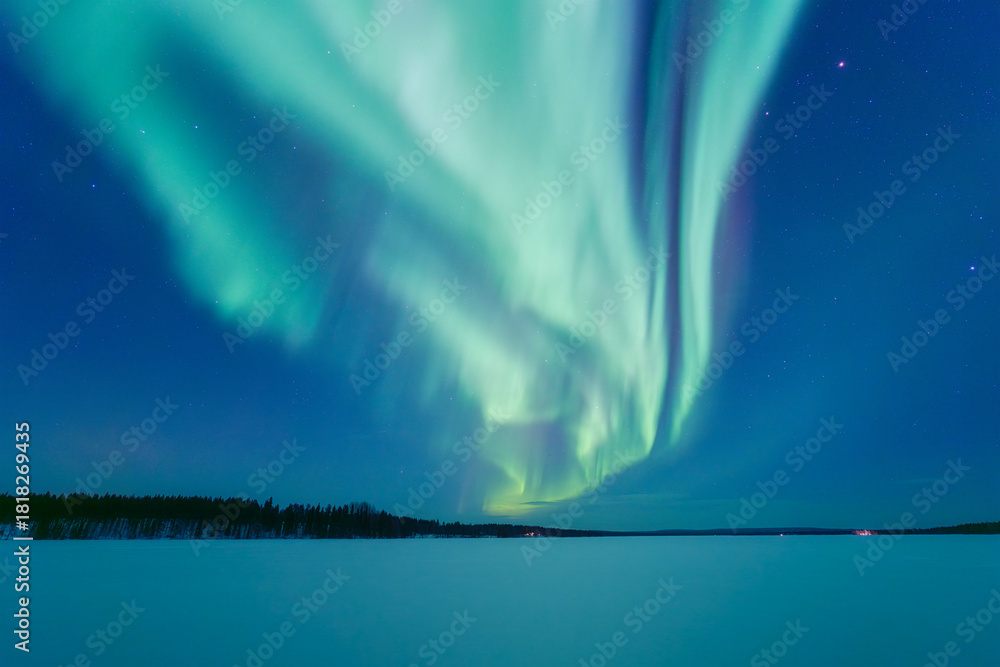 Fototapeta premium Aurora Borealis in Scandinavia. Northern lights over frozen lake and forest. Starry sky. Glow on the sky. Winter landscape on the north. Picturesque view. Photo for background, wallpaper, postcards.