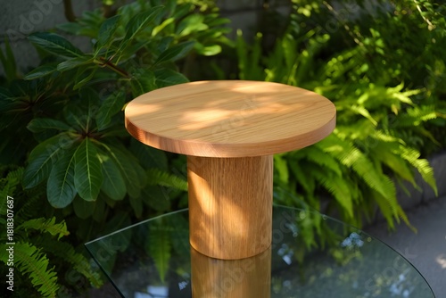Simple wooden pedestal stand with greenery background