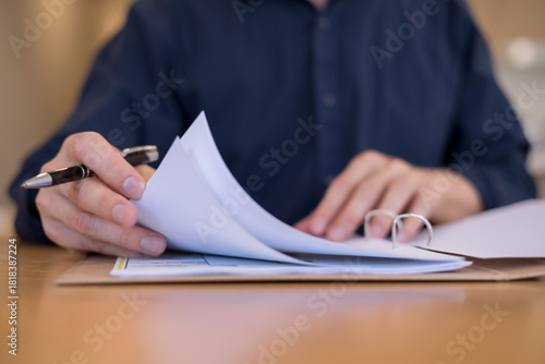 Obraz na plátně Close-up of hand flipping pages in document folder with pen