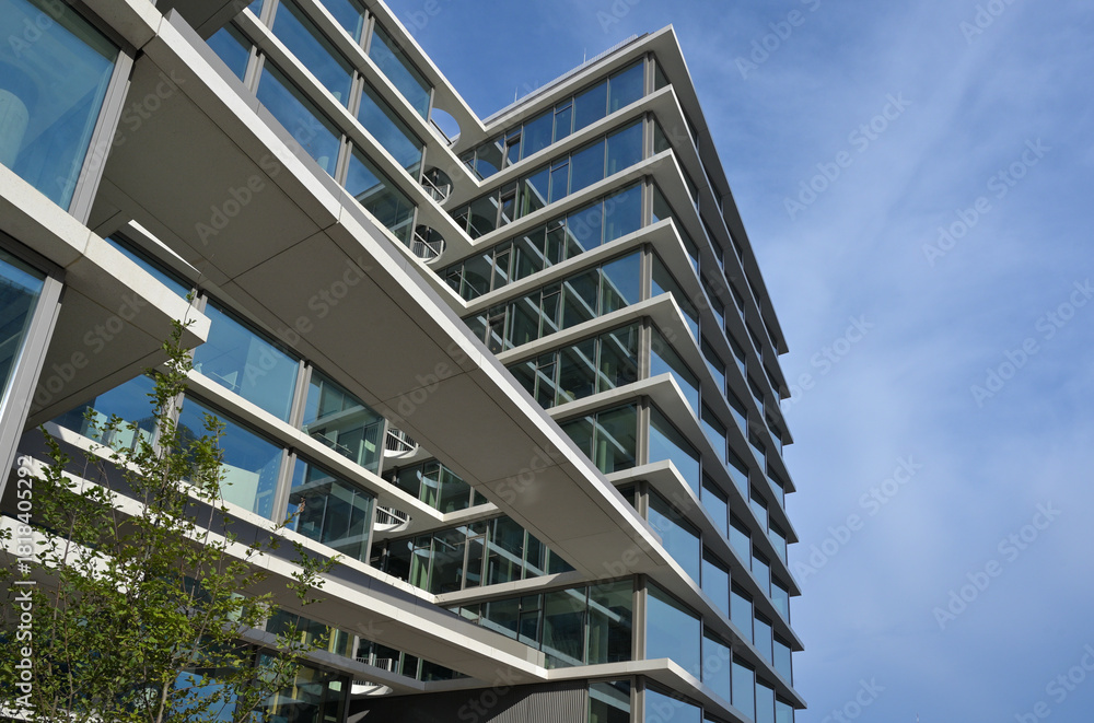 Fototapeta premium Modern metropolis. Contemporary architecture. Straight lines of buildings, blue sky. Structural glass and concrete. Geometry in architecture.Sunlight reflecting off the edges of buildings. Warsaw.