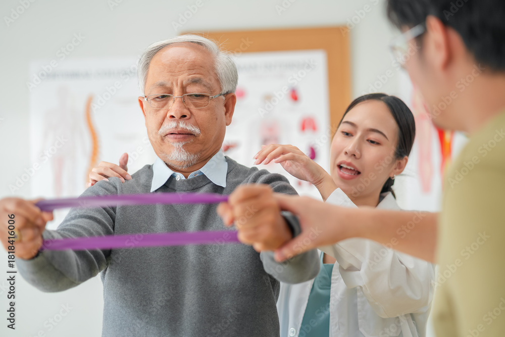Obraz premium A caring physical therapist guides a senior Asian woman through resistance band exercises during a rehabilitation session, helping her improve strength, mobility, and confidence. supportive therapy