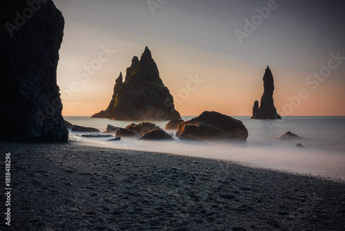 Canvastavla The Reynisdrangar basalt sea stacks rising through misty waves, at Reynisfjara b
