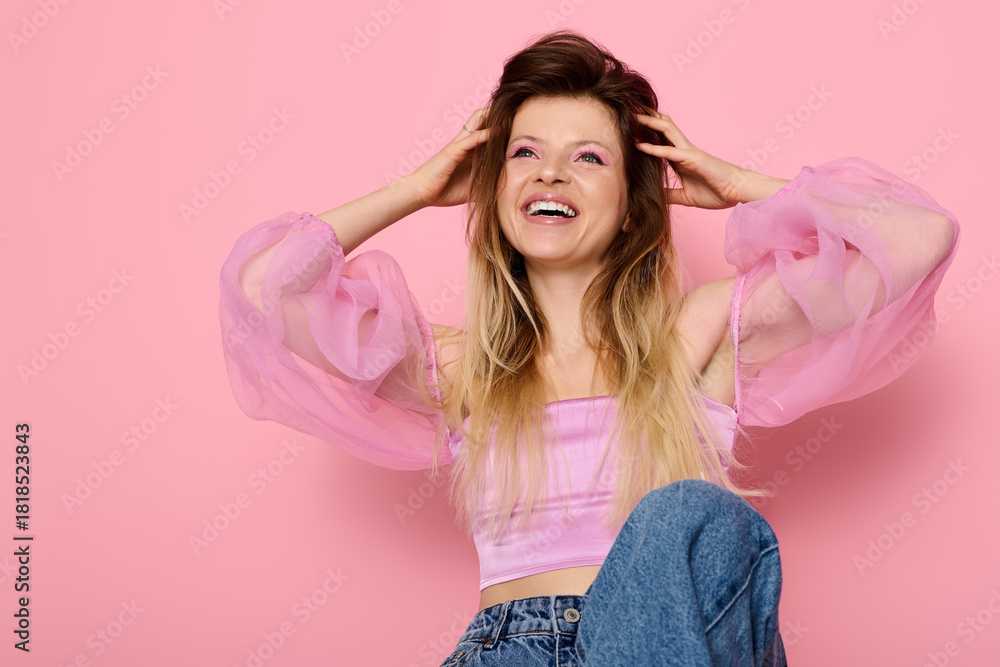 Φωτογραφία Joyful young woman in sheer pink blouse embracing beauty and fashion in a studio