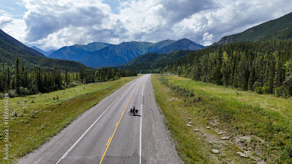 Naklejka premium Adventurous cyclist riding through stunning mountain landscape on open highway