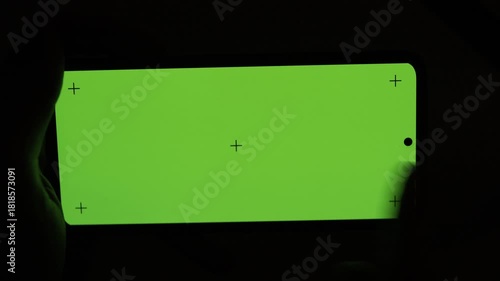 Nighttime close-up of fingers typing on a bright smartphone screen, showing a clear view of the large mobile display. Perfect for illustrating digital communication, texting, social media use.