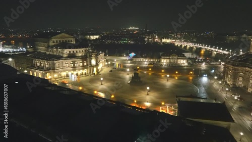 Night view over Theatre Square in Dresden featuring the brightly lit Semperoper and the wide plaza under a clear dark sky.